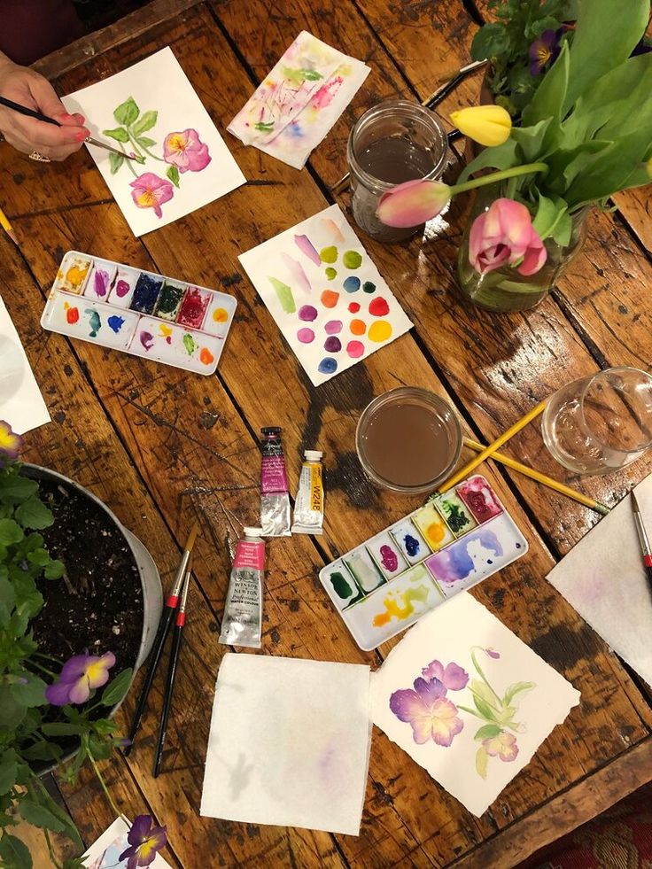 the table is covered with watercolors and flowers