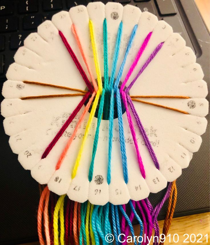 a bunch of colorful straws sitting on top of a white plate next to a laptop