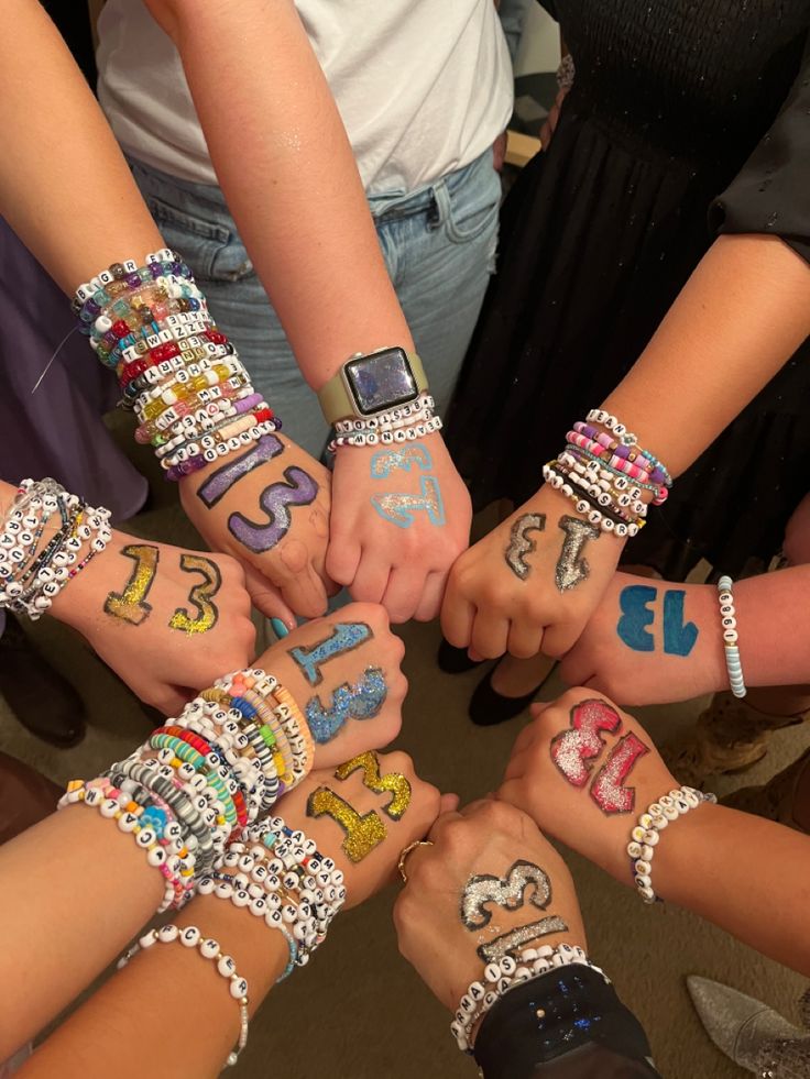 a group of people with their hands painted in different colors and numbers on their arms