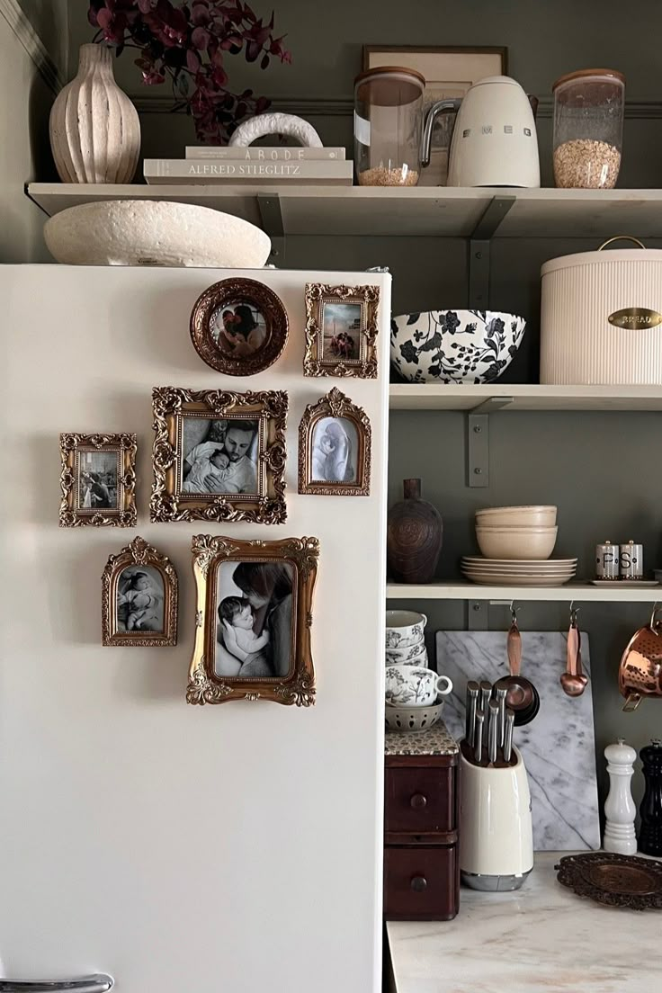 a white refrigerator freezer sitting inside of a kitchen next to shelves filled with pictures