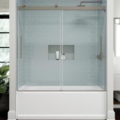 a bathroom with a glass shower door and white tile walls, along with a potted plant in the corner