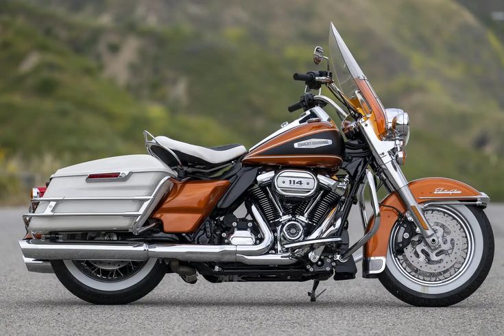 an orange and silver motorcycle parked on the street