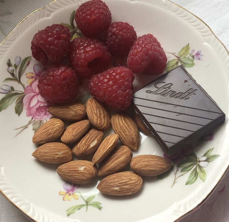 raspberries, almonds, and chocolate on a plate with the word lindt written on it