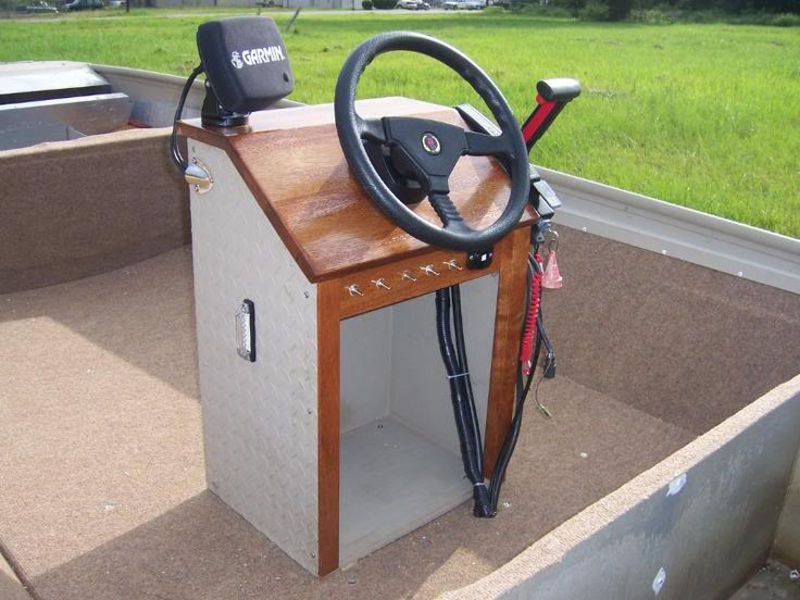 a steering wheel and some tools in the back of a small boat on the water