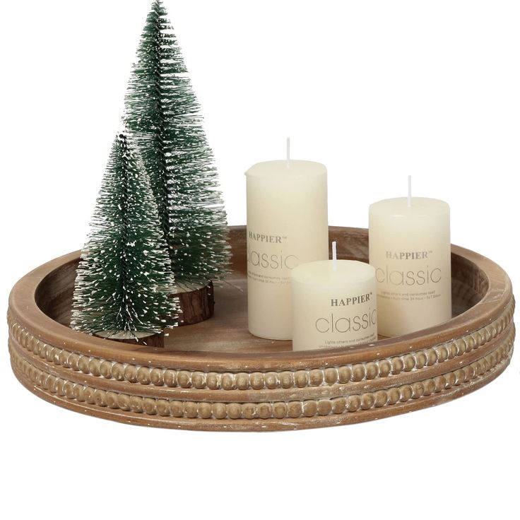 a tray with three candles and a small christmas tree on the bottom one is white