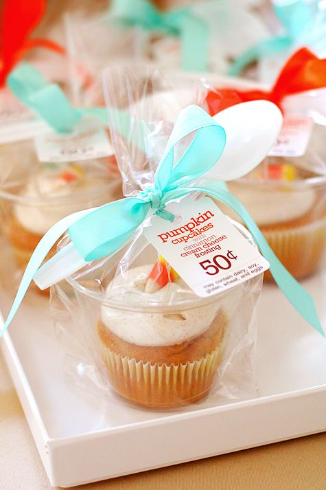 some cupcakes wrapped in plastic and sitting on a tray with ribbons around them