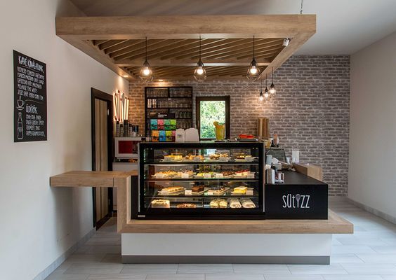 a bakery with lots of food inside of it's display case and shelves in front of the counter