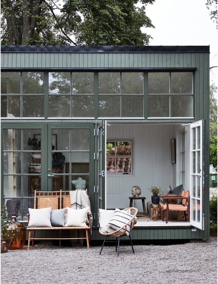 a green house with lots of windows and furniture