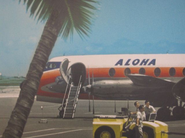 an orange and white plane is parked on the tarmac with people standing around it