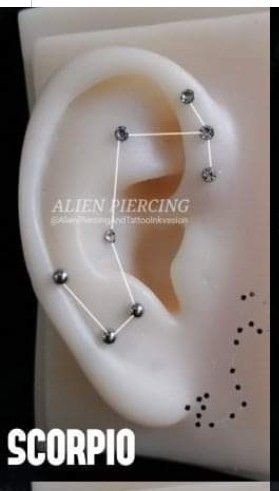 an ear piercing is shown with the zodiac sign on it