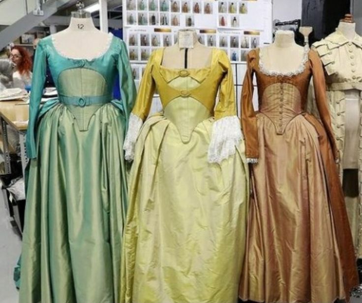 three dresses are on display in front of other mannequins wearing gowns