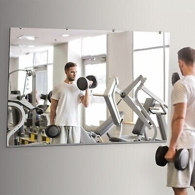 a man standing in front of a mirror with dumbbells on it and another man looking at his reflection