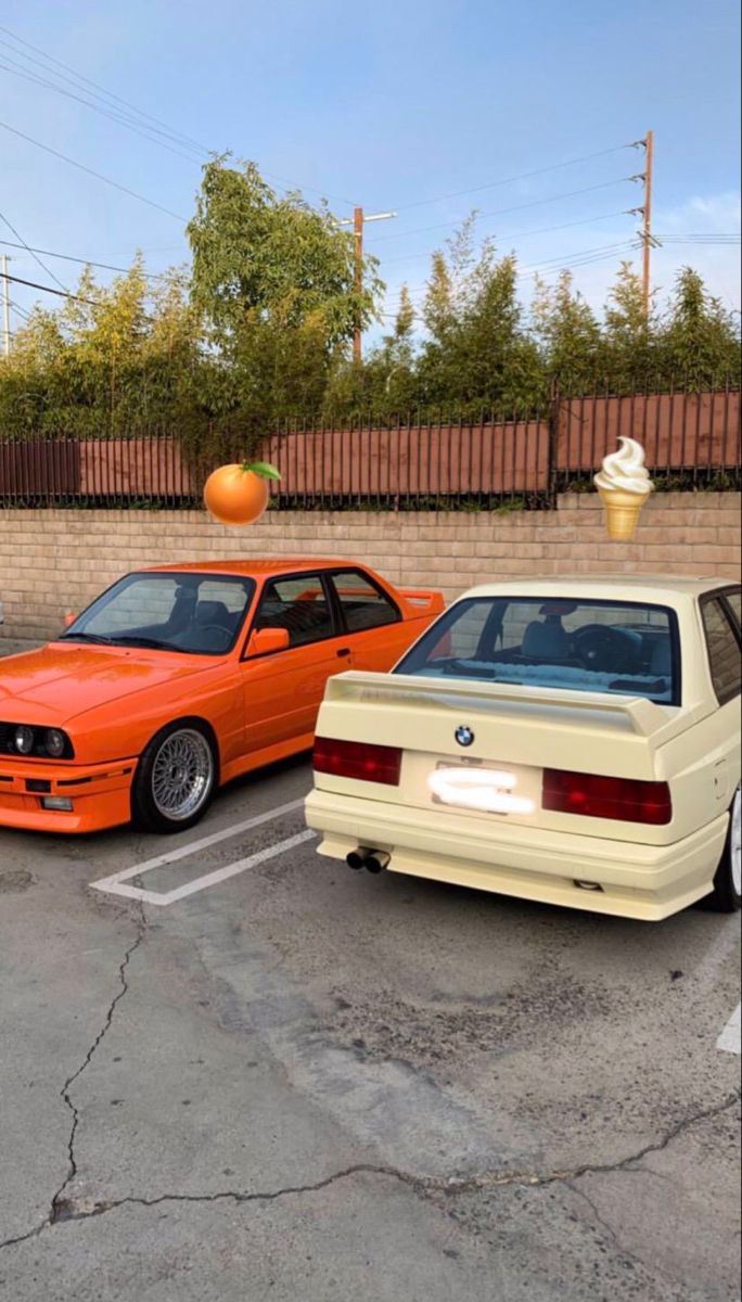 two cars parked next to each other in a parking lot near an ice cream cone