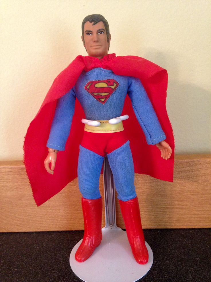 a superman action figure standing on top of a table