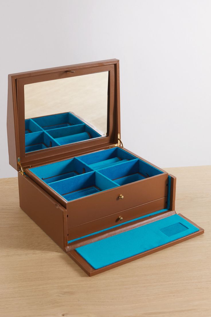 an open wooden jewelry box sitting on top of a table