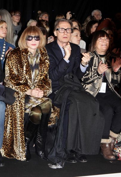 several people sitting next to each other at a fashion show