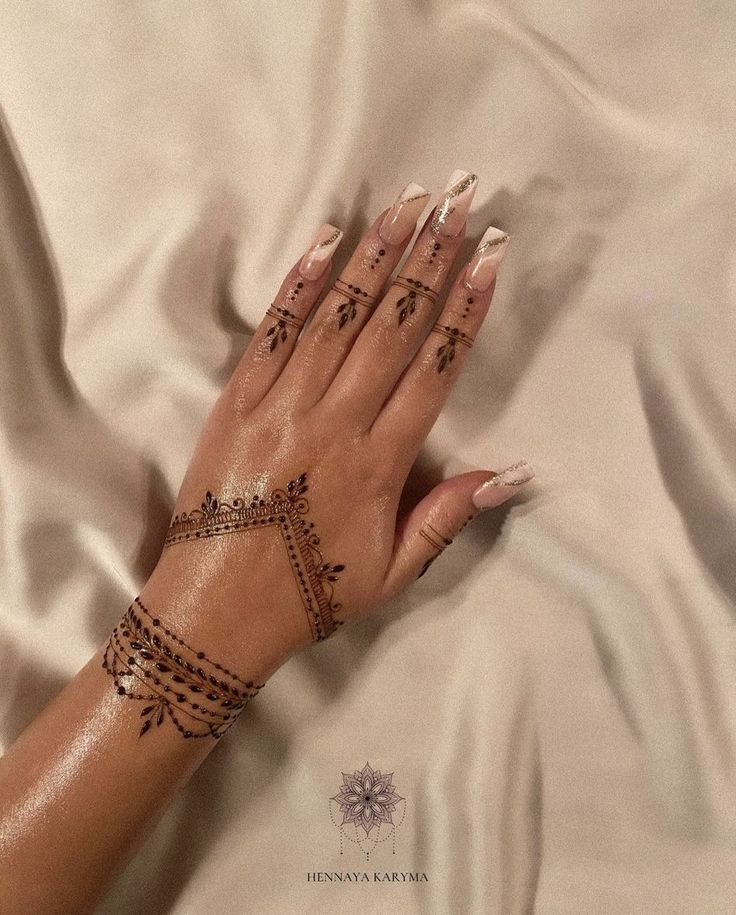 a woman's hand with hendix tattoos on her left arm and wrist