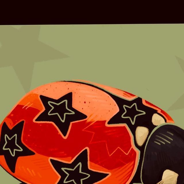 an orange and black shoe with stars painted on the side, sitting in front of a green background