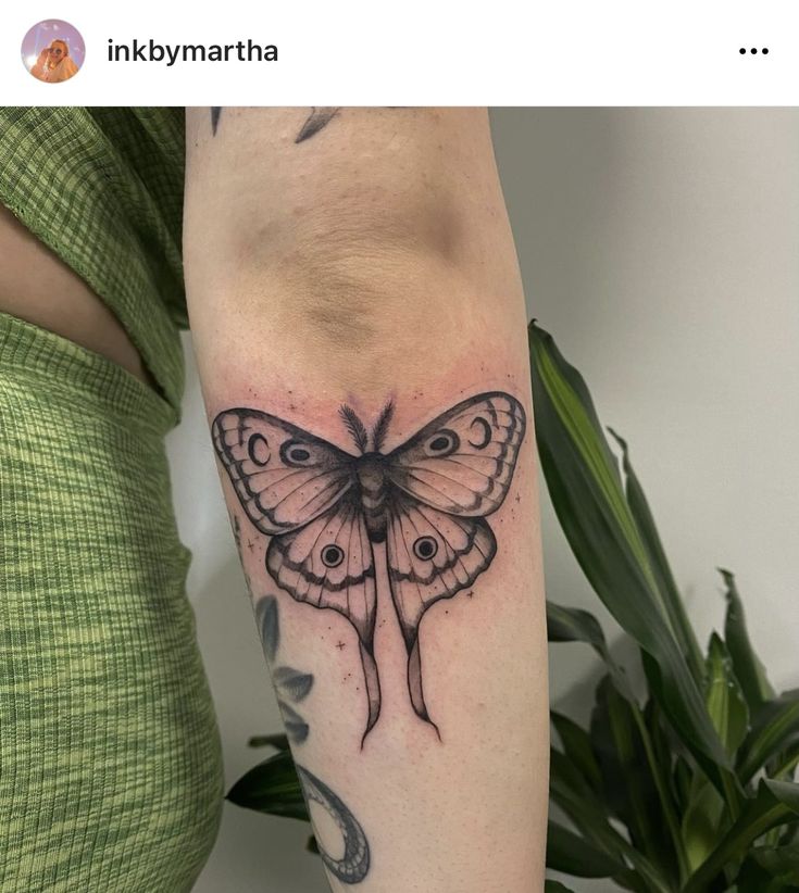 a woman's arm with a butterfly tattoo on the left side of her body