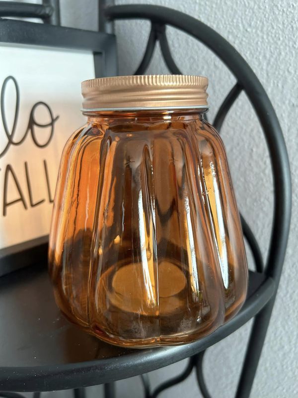 a glass jar sitting on top of a metal table next to a sign that says do all