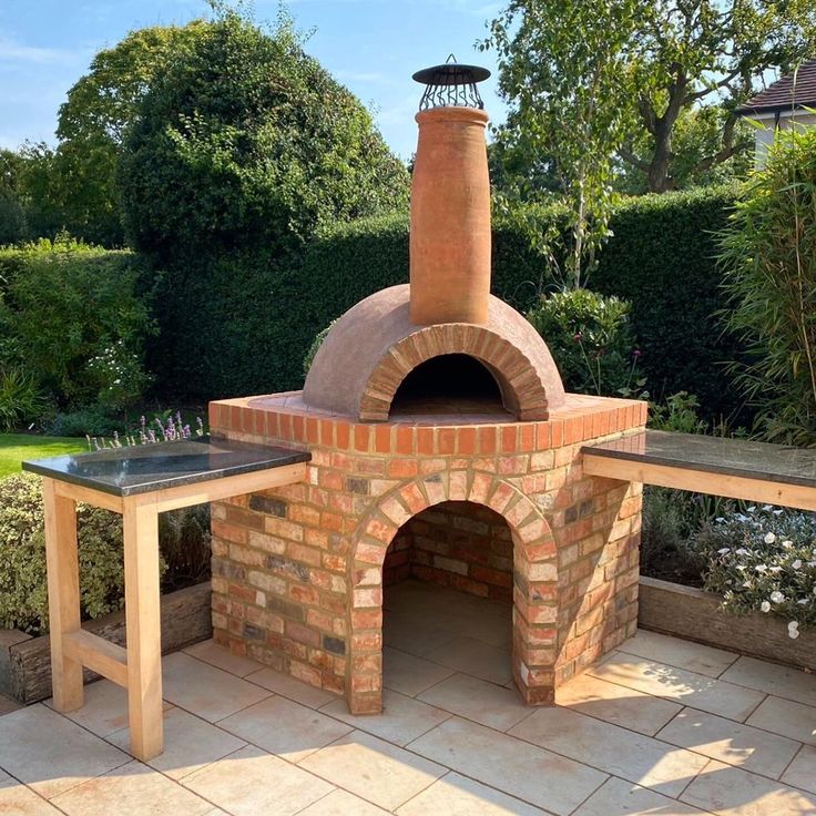 an outdoor brick pizza oven sitting on top of a patio