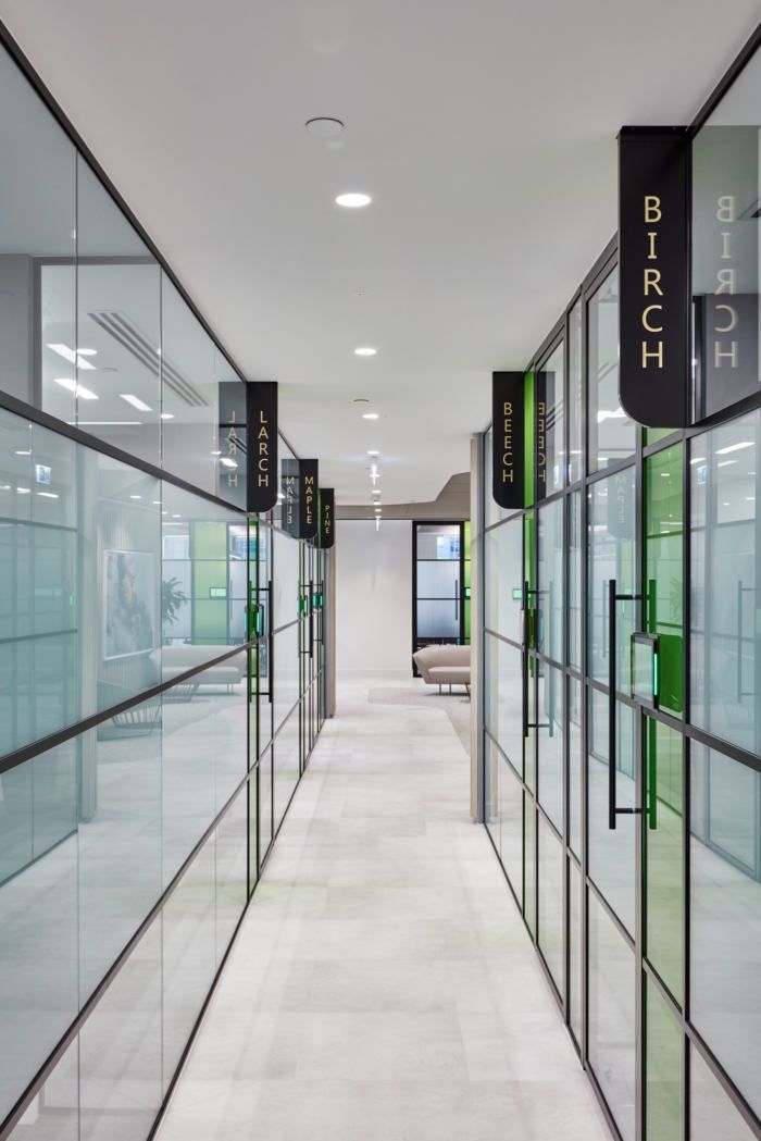 an empty hallway with glass walls and signs