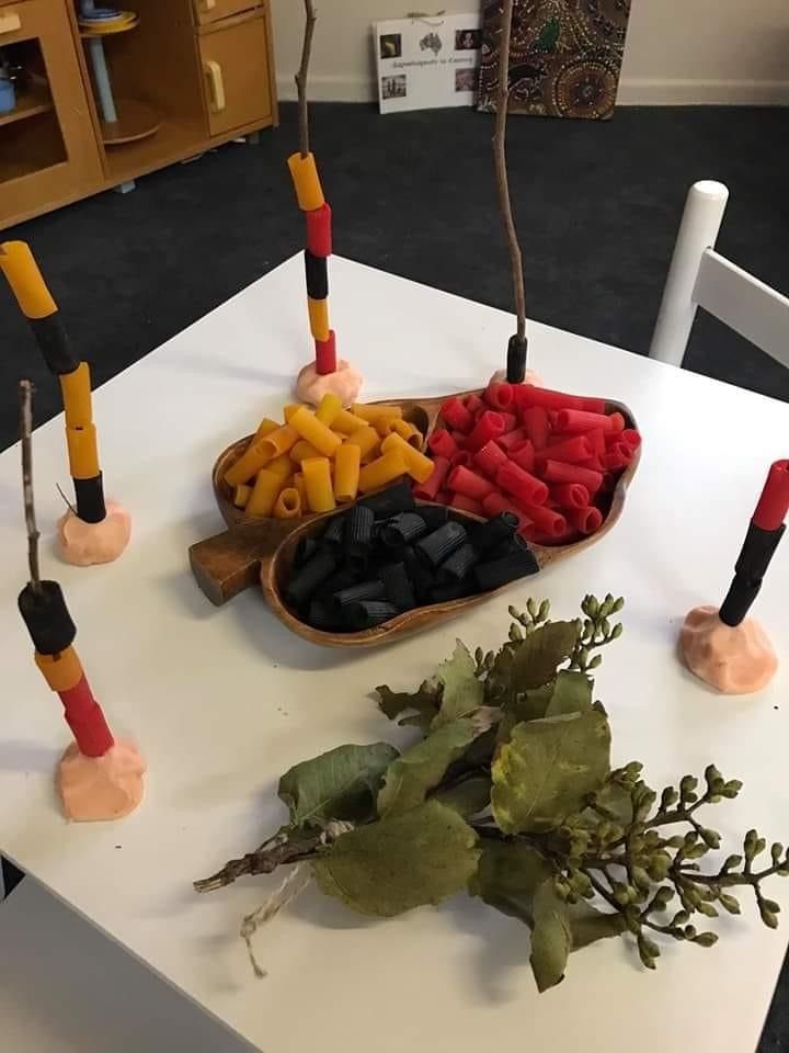 a white table topped with lots of different types of food on top of wooden spoons