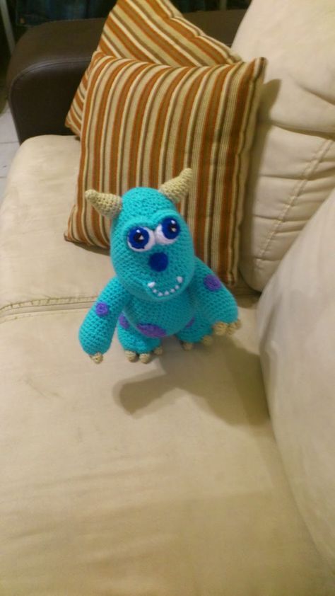 a blue stuffed animal sitting on top of a couch