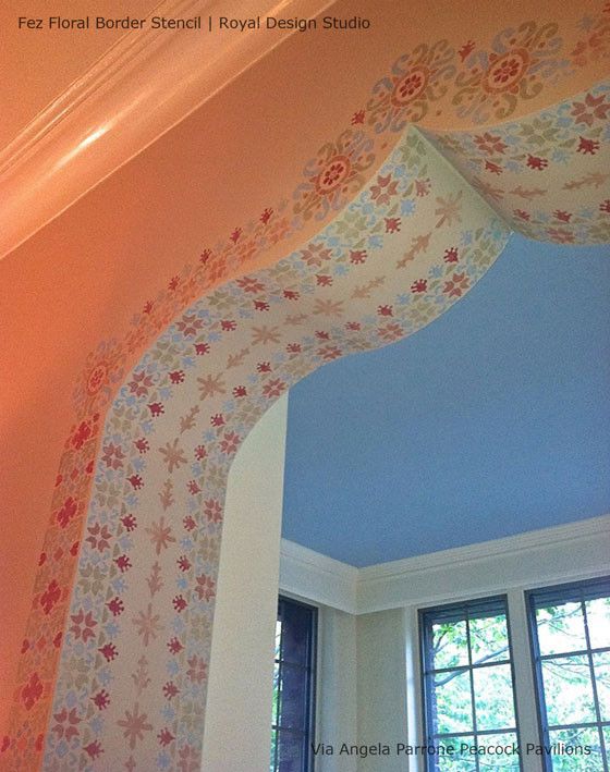 an arch in the corner of a room with curtains hanging from it's sides