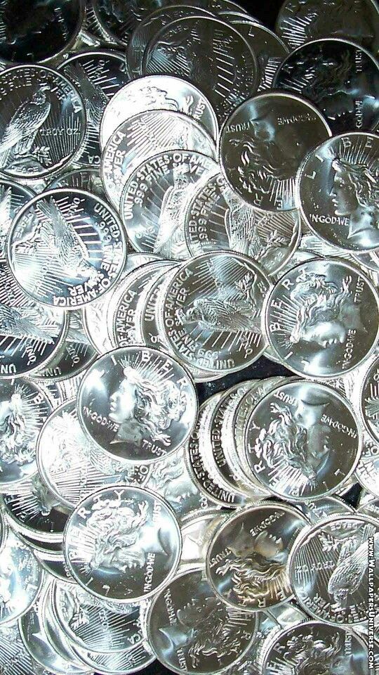 a pile of silver coins sitting next to each other on top of a metal table