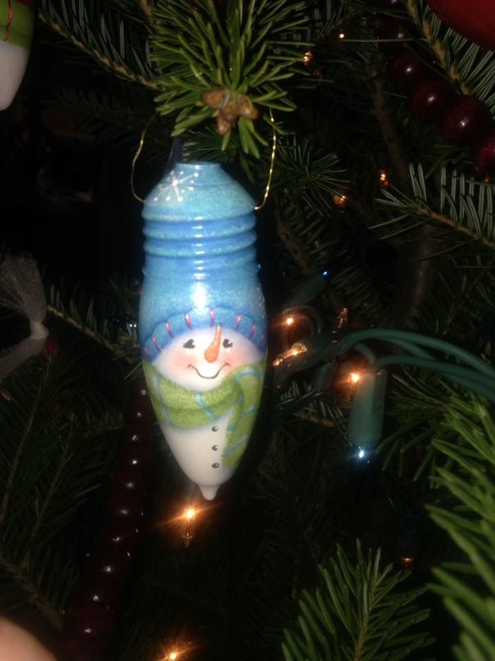 a snowman ornament hanging from a christmas tree