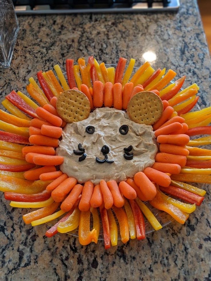 a lion made out of carrots and crackers on top of a granite counter