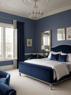 a bedroom with blue walls and white bedding, chandelier, two chairs, and windows