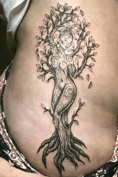 a woman's stomach with a tree tattoo on it