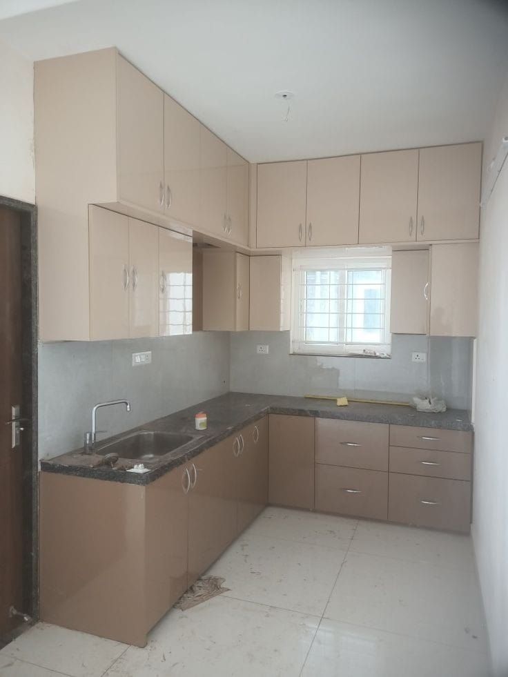 an empty kitchen is shown in the middle of being painted pink and white with brown cabinets