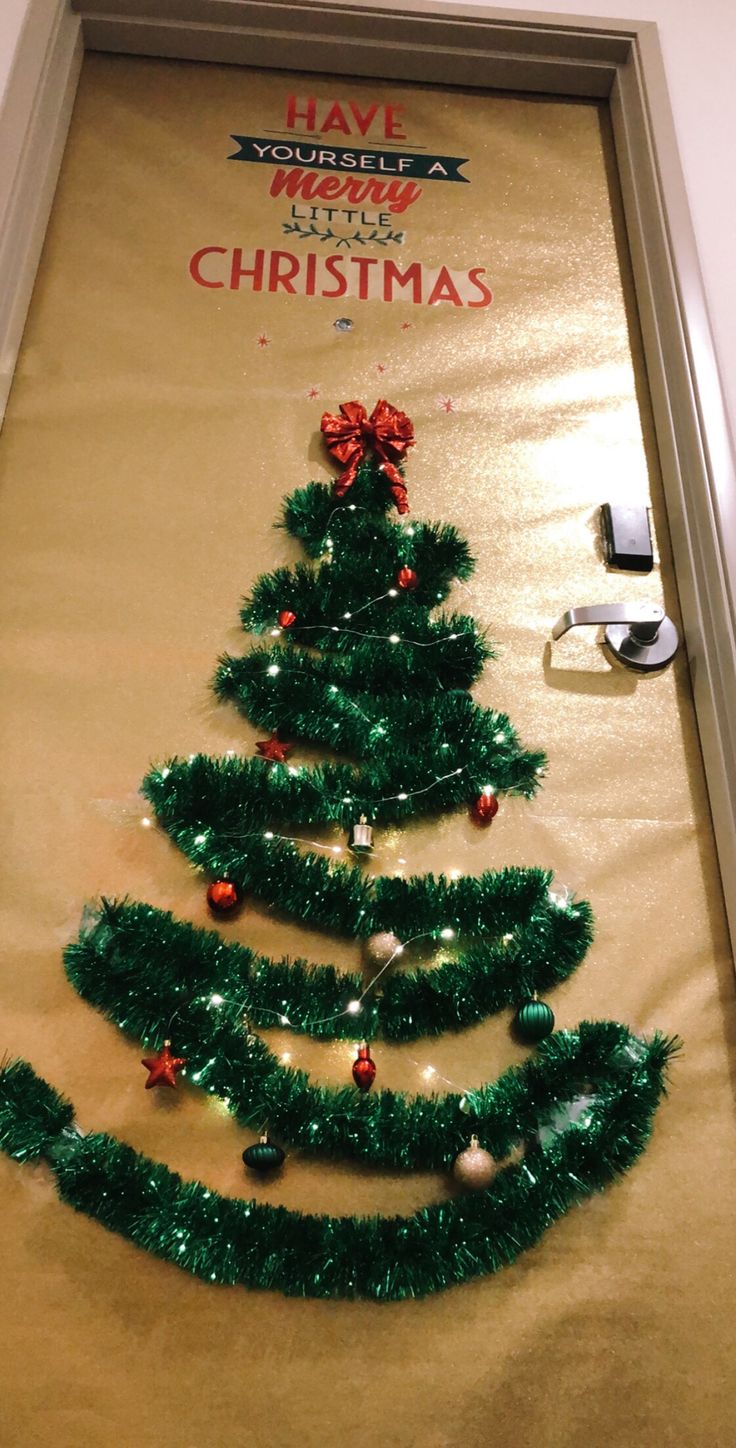 a christmas tree made out of tinsel is on the wall in front of a door