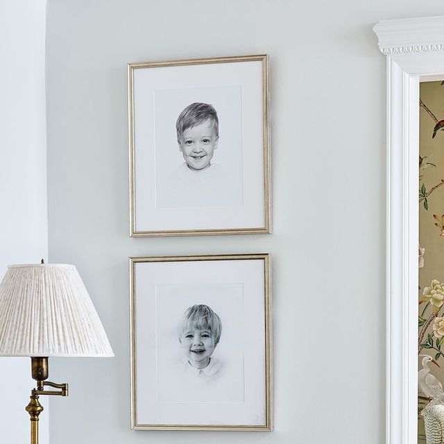 two framed pictures hang on the wall next to a table with a lamp and chair