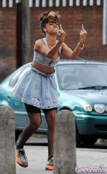 a woman on a skateboard with her mouth open and one hand up in the air