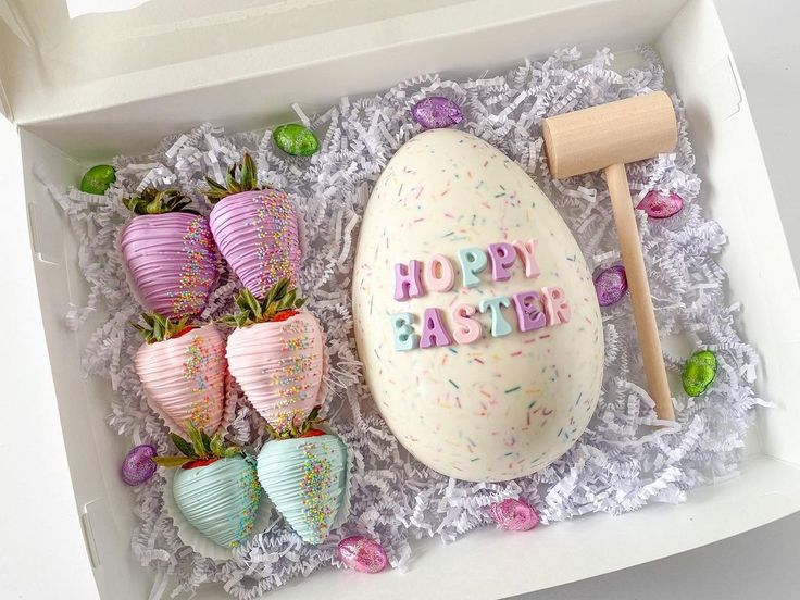 an easter egg and strawberries in a box with the words happy easter written on it