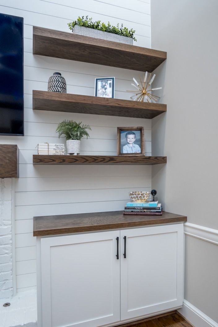 a tv mounted on top of a wooden shelf