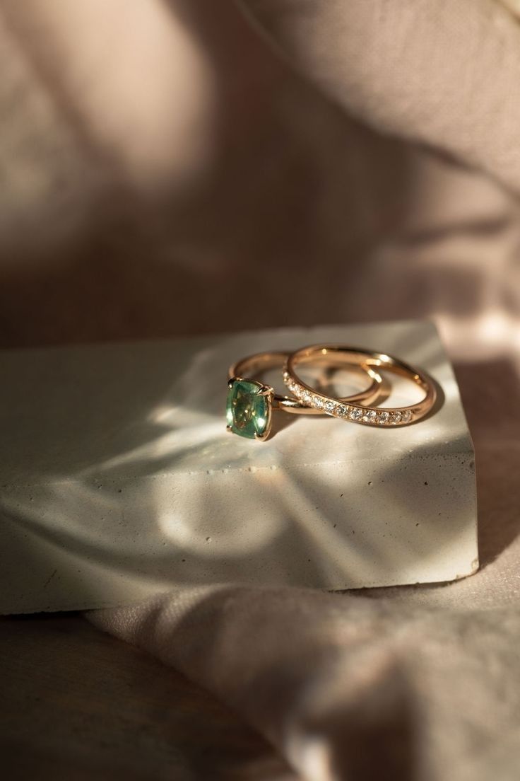 two wedding rings sitting on top of a white piece of paper next to each other