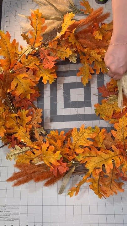 someone is making a wreath out of leaves