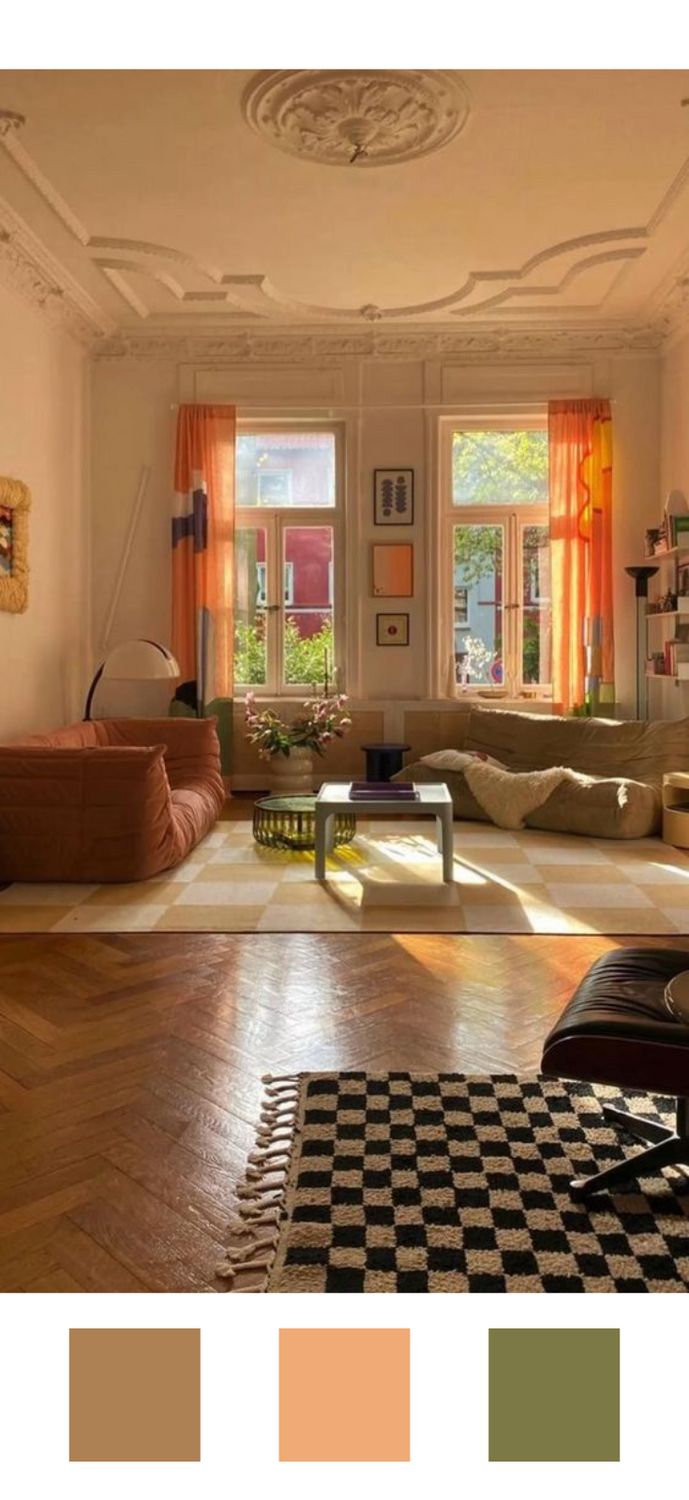 a living room filled with lots of furniture and windows covered in bright orange drapes