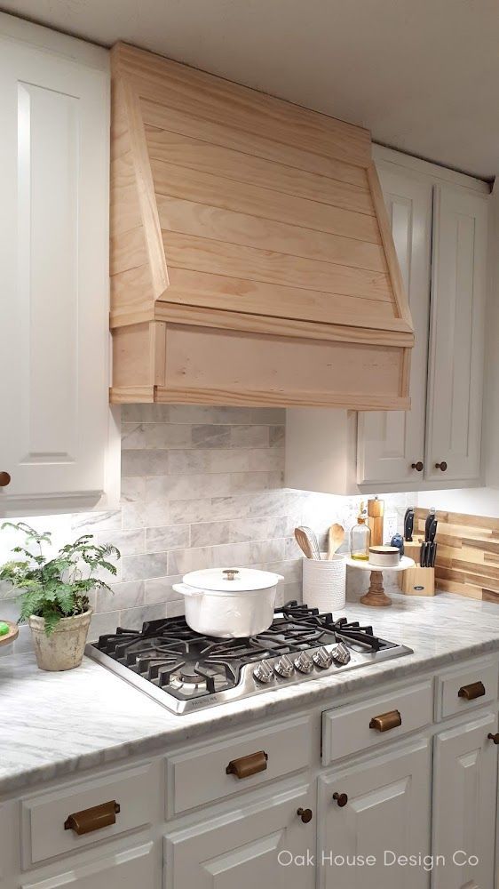 a stove top oven sitting inside of a kitchen next to white cabinets and counter tops