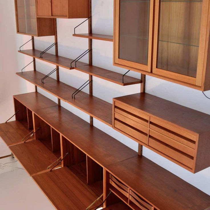 an empty room with wooden shelves and cupboards on the wall next to each other