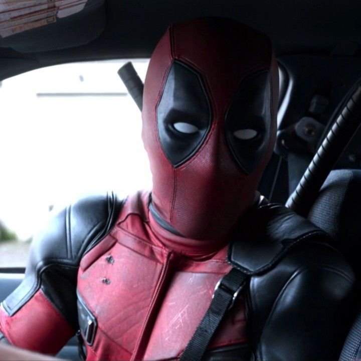 deadpool is sitting in the back seat of a car