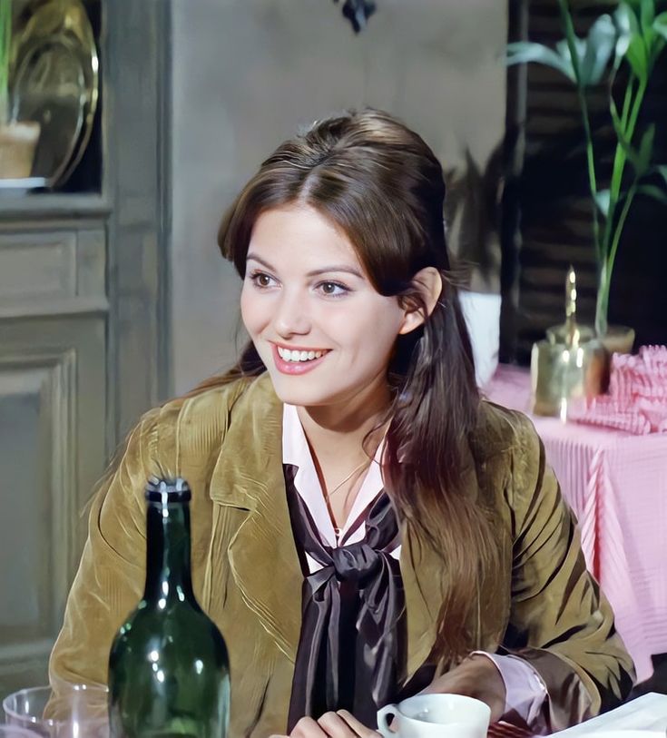 a woman sitting at a table with a cup and saucer