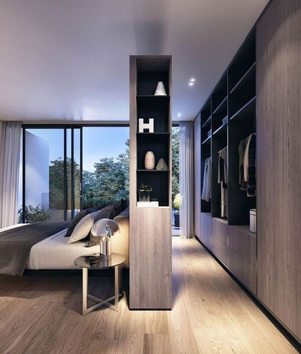 a bedroom with wooden flooring and built in closets next to a window that looks out onto the outdoors