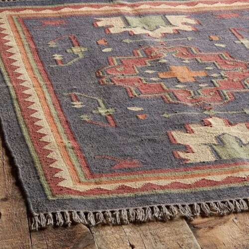 an old rug is laying on the floor with some wood planks in front of it