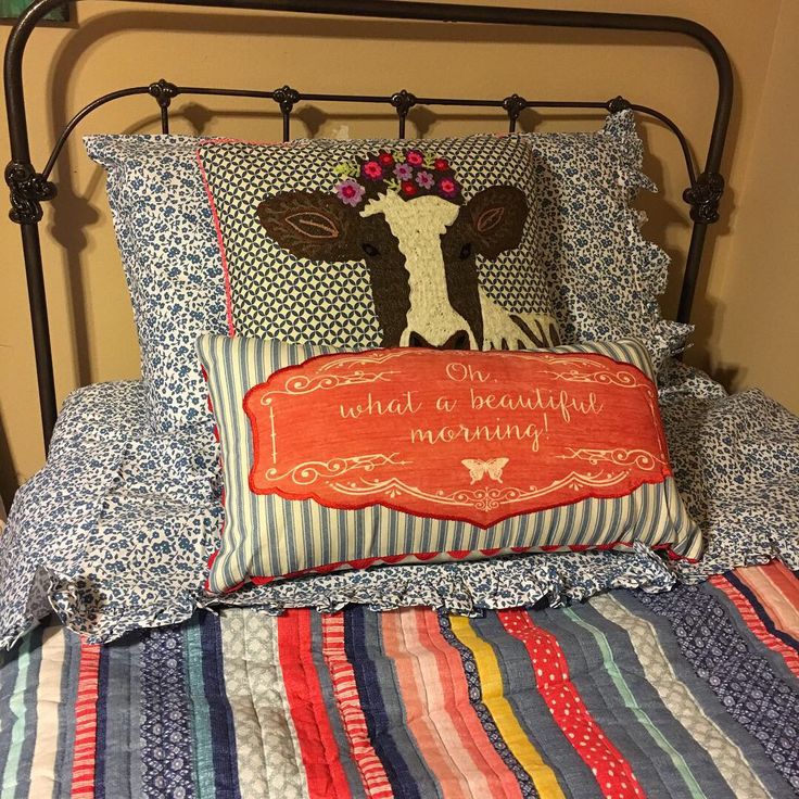 a bed topped with pillows covered in colorful blankets